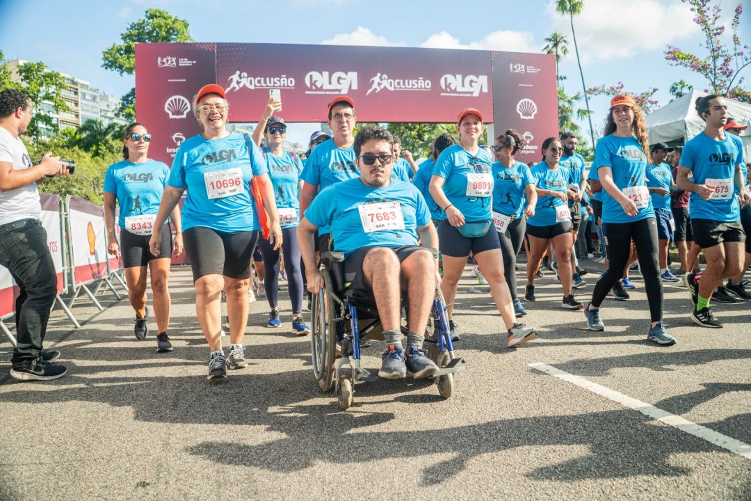 Imagem Corrida da Inclusão, a frente um cadeirante, atrás pessoas caminham