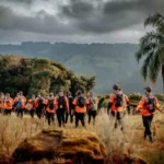 Imagem homens caminhando em área rural com mata
