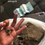Imagem Maconha na mão e um anota de cem reais