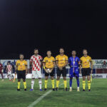 Imagem capitães de Trindade e Anapolina e trio de arbitragem posando para foto antes do início do jogo