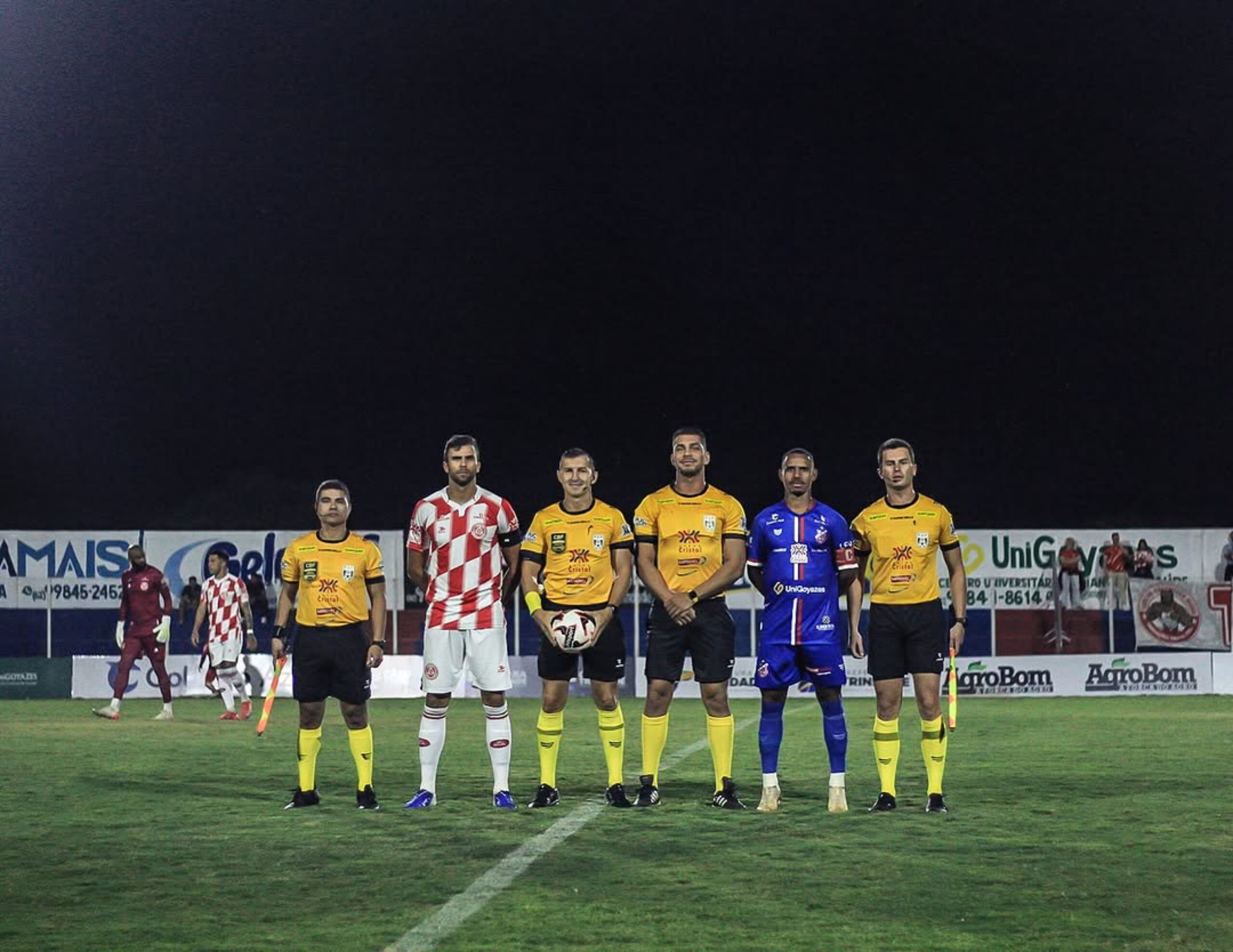 Imagem capitães de Trindade e Anapolina e trio de arbitragem posando para foto antes do início do jogo