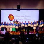 A imagem mostra 22 pessoas recebendo uma homenagem