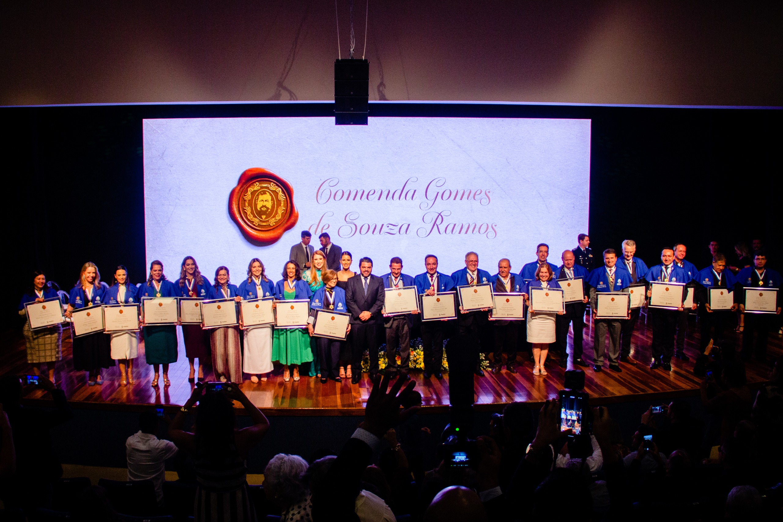 A imagem mostra 22 pessoas recebendo uma homenagem