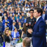 Imagem Daniel Vilela falando para grande publico, ele está segurando o microfone