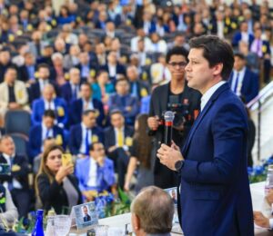 Imagem Daniel Vilela falando para grande publico, ele está segurando o microfone