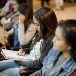 A imagem mostra alunos sentados estudando