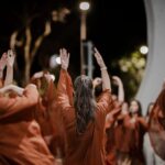 Imagem mulheres em apresentação, elas estão com as mãos para cima