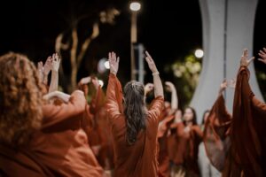 Imagem mulheres em apresentação, elas estão com as mãos para cima