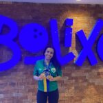 Imagem atleta Aléxia sorrindo, segurando uma medalha