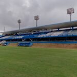 Imagem Estádio Jonas Duarte - Arquibancada Coberta, aparece o banco de reservas e uma parte do gramado do campo