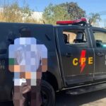 Imagem homem preso, a imagem está embassada ele está na frente de uma viatura da CPE