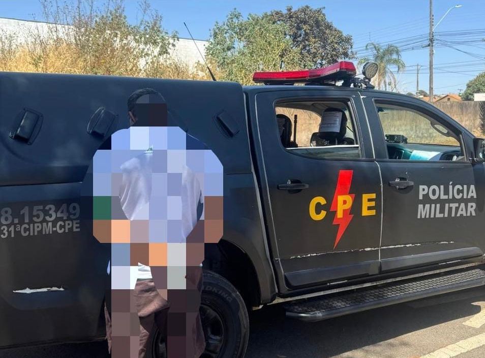 Imagem homem preso, a imagem está embassada ele está na frente de uma viatura da CPE