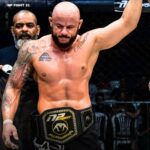 Imagem Junior Magal com o braço erguido e com o cinturão