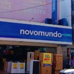 Imagem fachada Loja Novo Mundo Centro Anápolis, na porta estão eletrodomésticos com cartaz de venda, Geladeira, tanquinho, fogão e outros