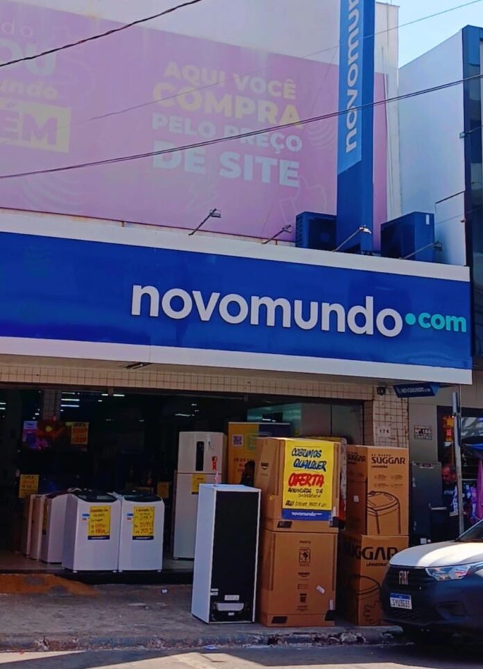 Imagem fachada Loja Novo Mundo Centro Anápolis, na porta estão eletrodomésticos com cartaz de venda, Geladeira, tanquinho, fogão e outros