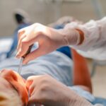 Imagem atendimento odontológico, dentista coloco material na boca do paciente