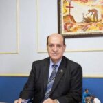 A imagem mostra o fundador da missão vida sentado atrás de uma mesa.