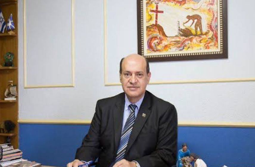 A imagem mostra o fundador da missão vida sentado atrás de uma mesa.