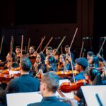 Imagem Orquestra Jovem de Anápolis eles estão com o violino e as varetas em posição para tocar