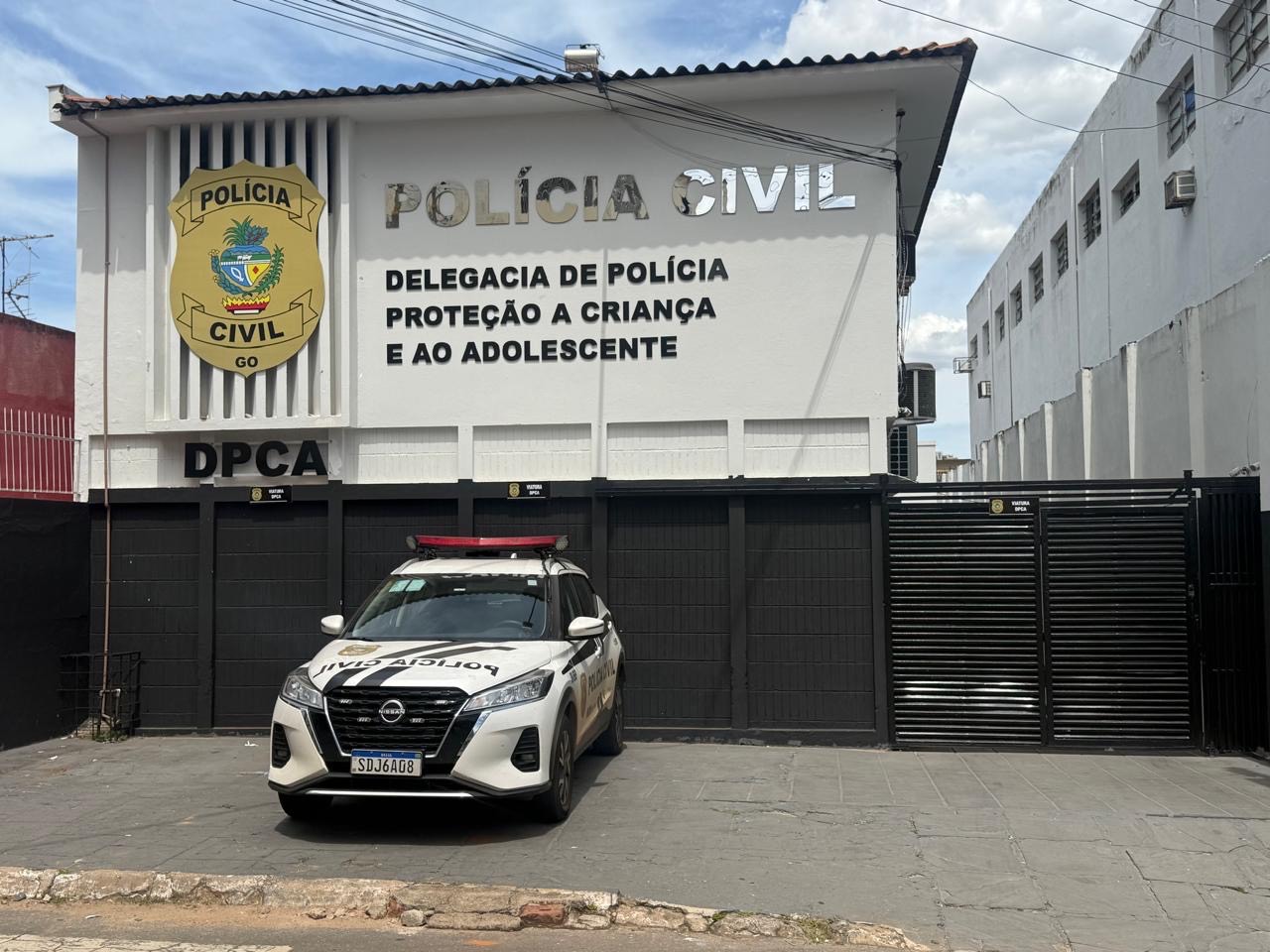 Imagem fachada Delegacia de Proteção à Criança e ao Adolescente (DPCA). tem uma viatura branca da PCGO na frente do prédio
