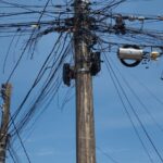 Imagem poste com vários fios entrelaçados na parte alta