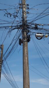 Imagem poste com vários fios entrelaçados na parte alta