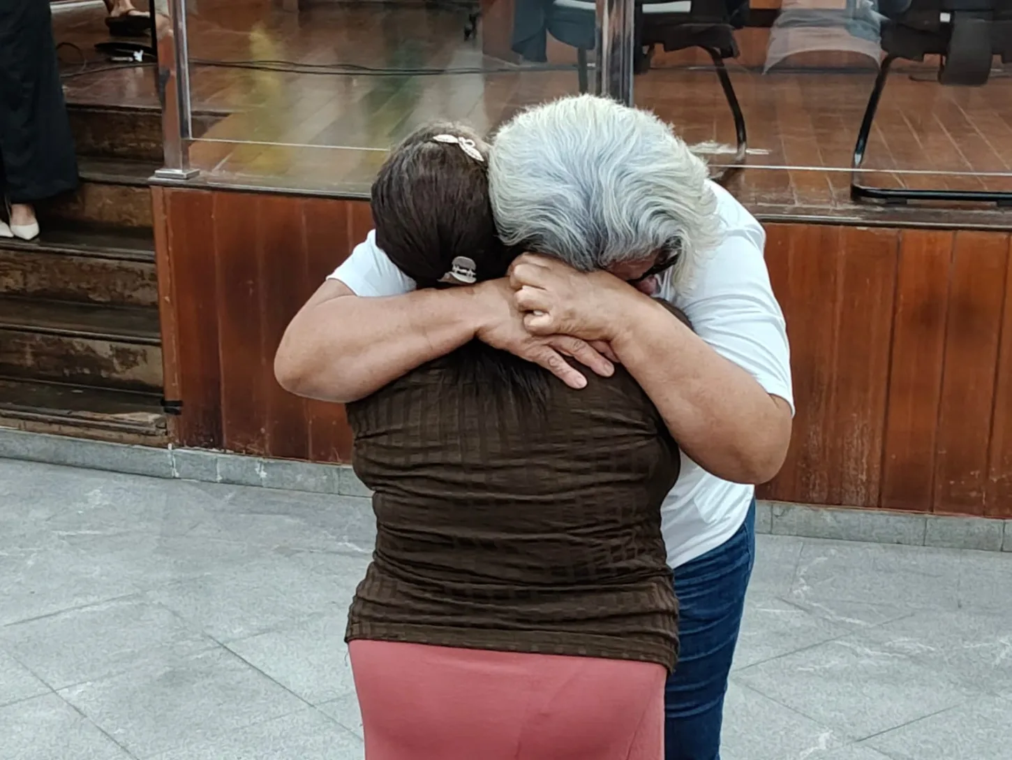 Imagem mãe de vitima e de ré se abraçam após julgamento do fórum