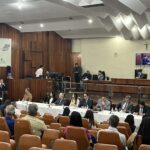 Imagem várias pessoas sentadas em uma audiência publica no Fórum de Anápolis