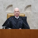 Imagem Edson Fachin ele está de toga preta e sentado em uma banca