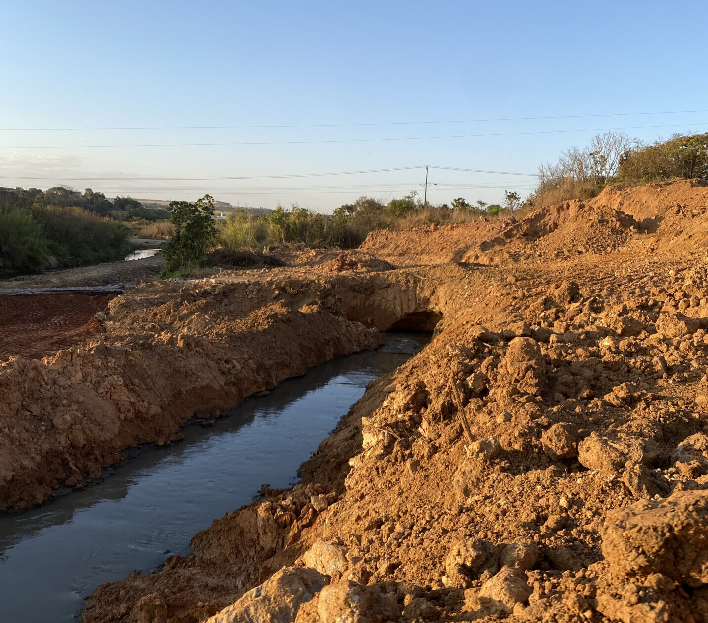Imagem esgoto escorrendo no meio da terra em região rural