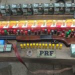 Imagem Espingarda e diversas munições em cima da mesa