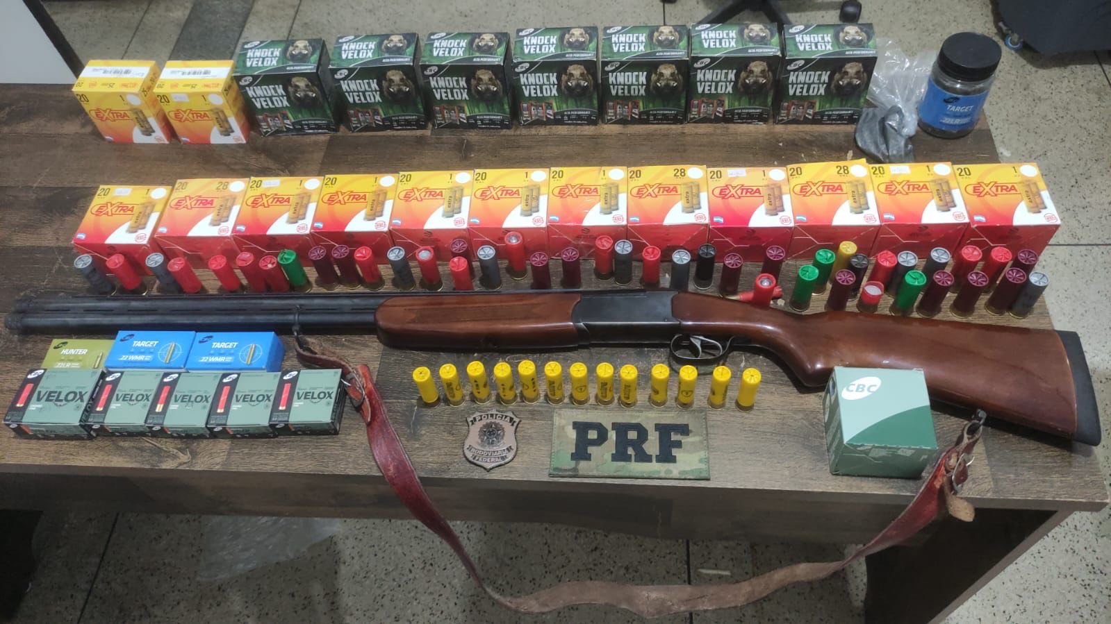Imagem Espingarda e diversas munições em cima da mesa
