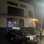 Imagem 1º DP Delegacia Geral, tem uma viatura da Policia Civil na porta e está a noite