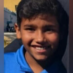 Imagem João Vitor sorrindo, ele está de camisa azul