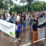 Imagem Marcha Para Jesus em Anápolis, várias pessoas na rua, algumas estão seguranda uma faixa