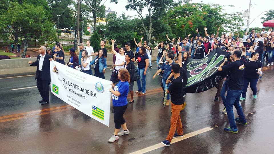 Imagem Marcha Para Jesus em Anápolis, várias pessoas na rua, algumas estão seguranda uma faixa