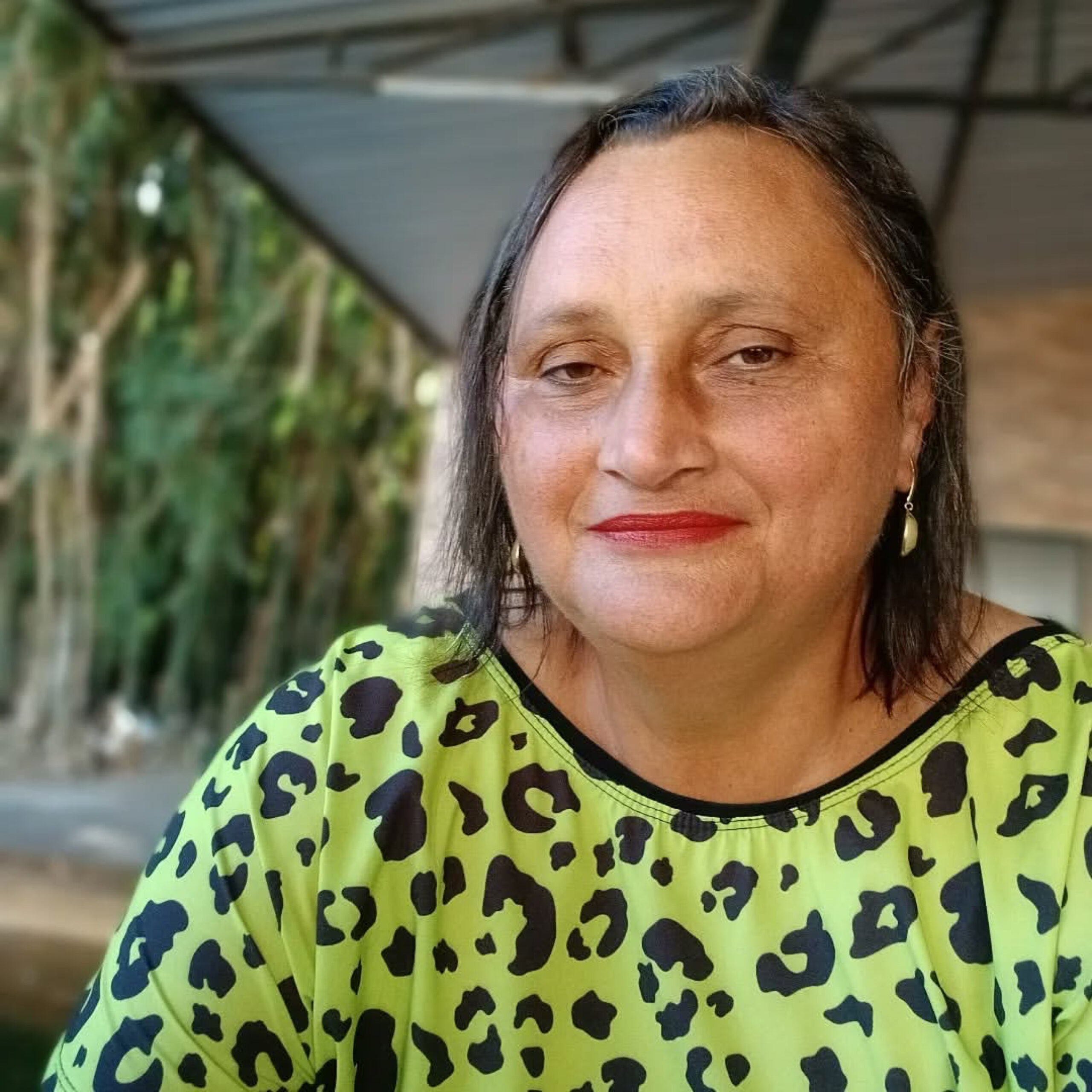 Imagem Maria Auxiliadora Leite, de camisa verde com detalhes em preto, ela está sorrindo.