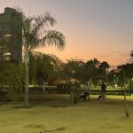 Imagem Parque Ipiranga Anápolis, está começando a ficar escuro, duas pessoas aparecem ao fundo passeando com cachorros