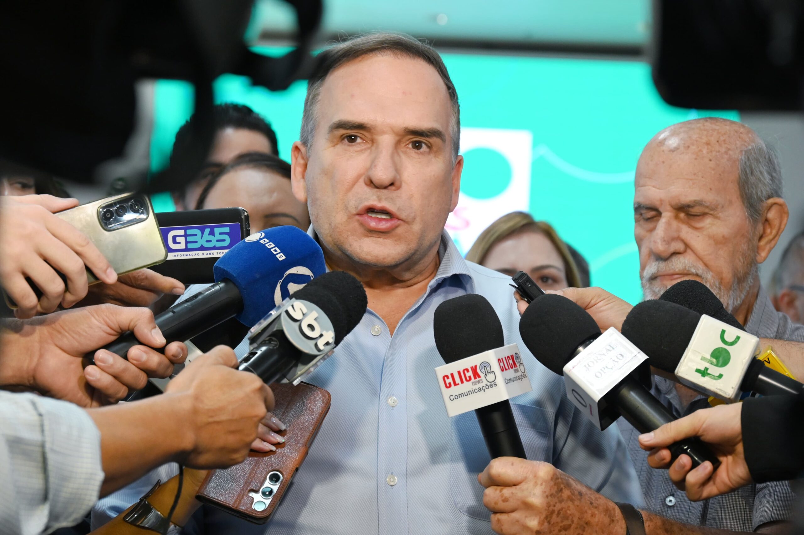 Imagem Sandro Mabel falando para os repórteres com os microfones a frente dele