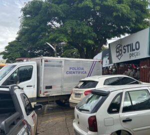 Imagem fachada loja Stilo Peças, na frente tem um veiculo da Polícia Cientifica e outros carros