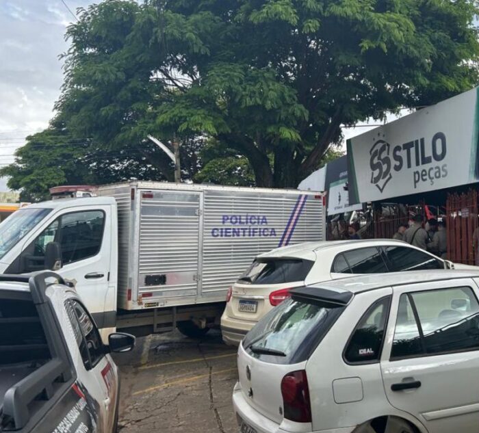 Imagem fachada loja Stilo Peças, na frente tem um veiculo da Polícia Cientifica e outros carros