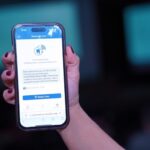 Imagem mão segurando um celular conectado no aplicativo Tele Estomago
