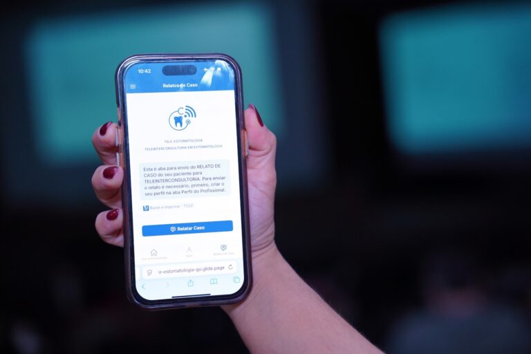 Imagem mão segurando um celular conectado no aplicativo Tele Estomago