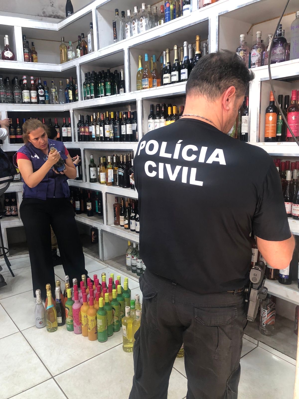 Imagem policia civil dentro de estabelecimento que vende bebidas alcolicas