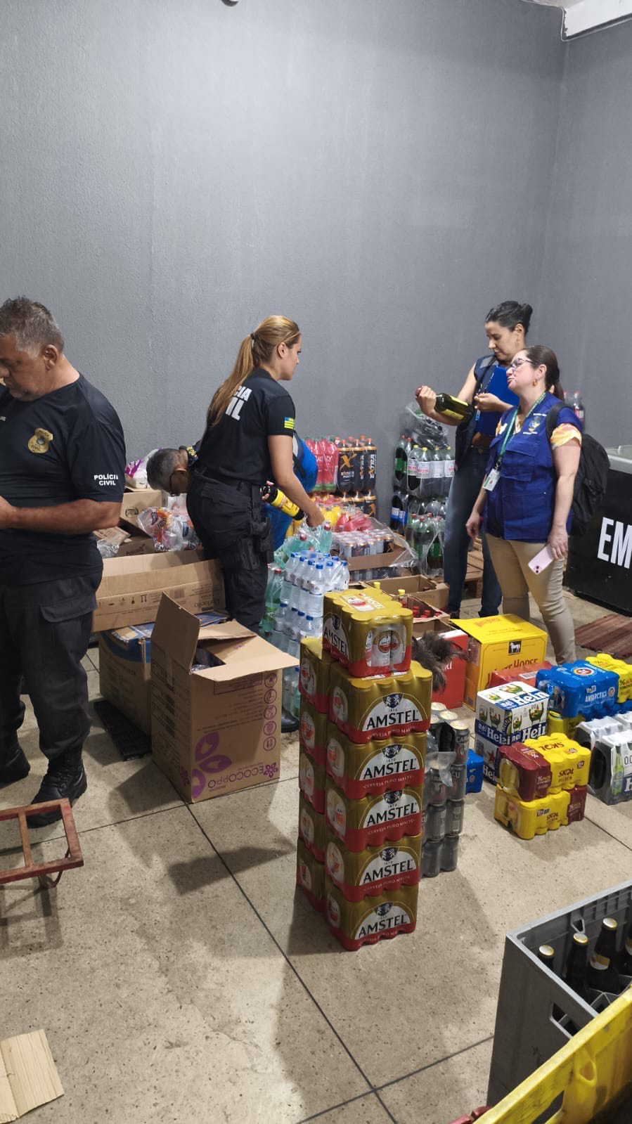 Imagem policiais ao lado de bebidas alcoólicas, cervejas e outros