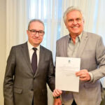 Imagem duas pessoas segurando documento