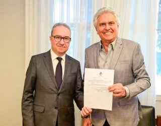 Imagem duas pessoas segurando documento