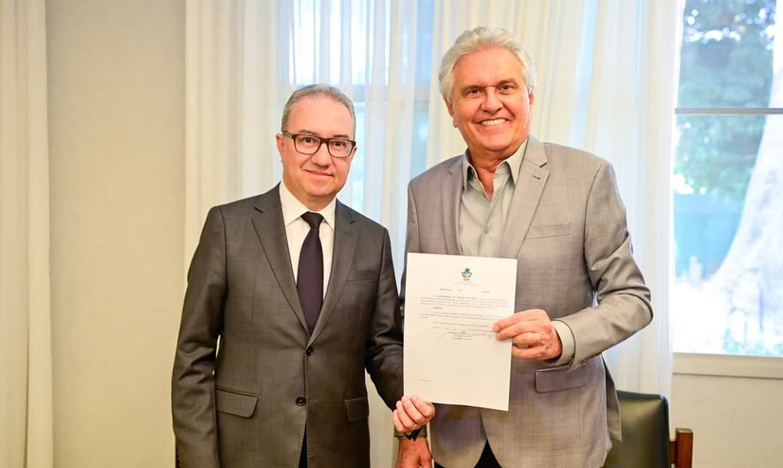 Imagem duas pessoas segurando documento