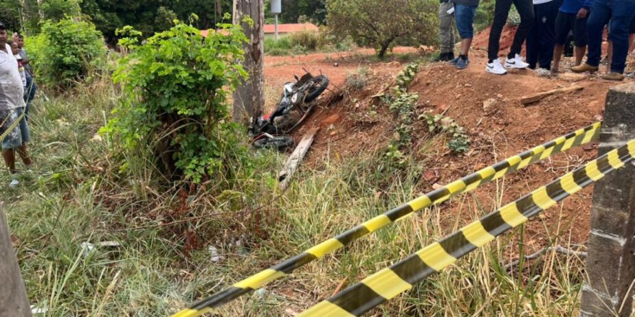 Imagem faixa zebrada ao fundo pessoas em pé e moto caida