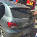 Imagem carro e homem preso de cabeça baixa